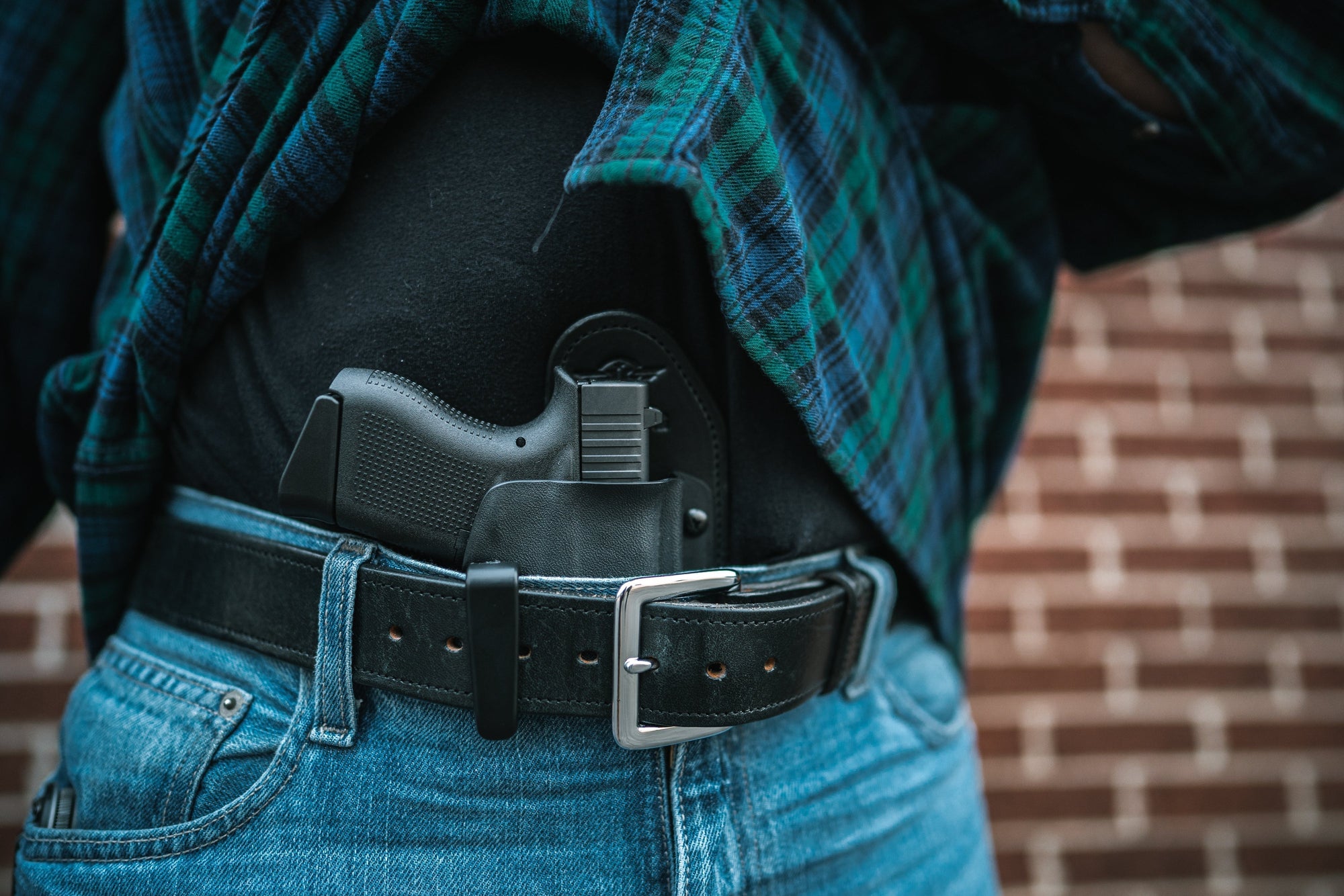 Man in Jeans and Flannel carrying a Glock 43x in a Hidden Hybrid Holsters Appendix Holster