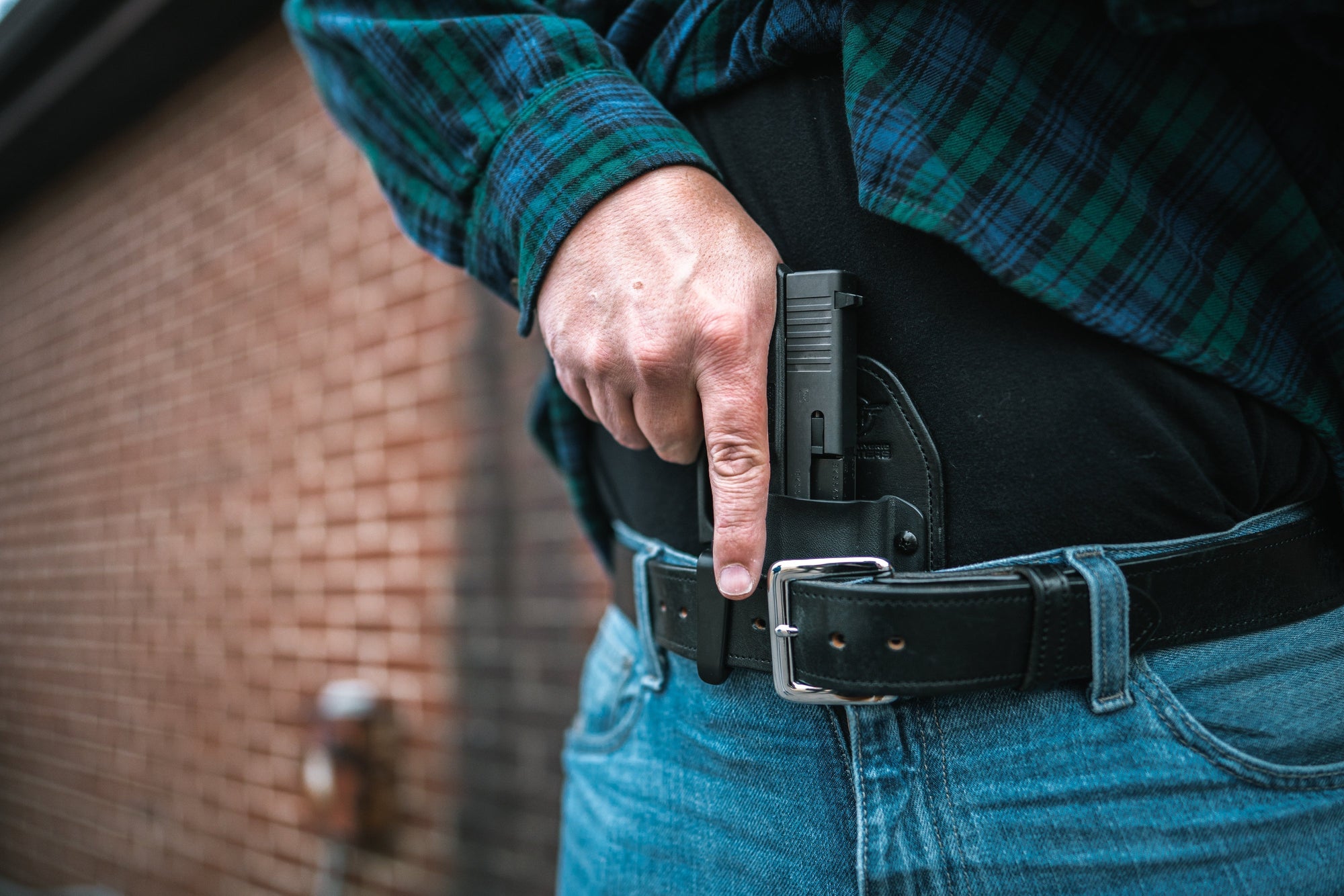 Man in Jeans and Flannel drawing from a Hidden Hybrid Holsters Appendix Holster